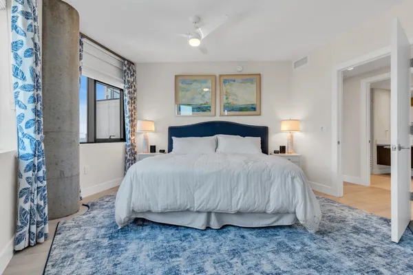 a bedroom with a large bed and windows