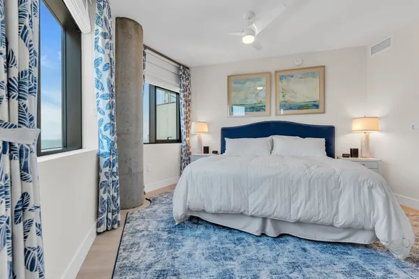 a bedroom with a bed and a flat tv screen on wall