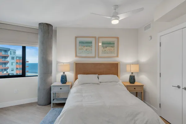 a bedroom with a bed and a potted plant on dresser