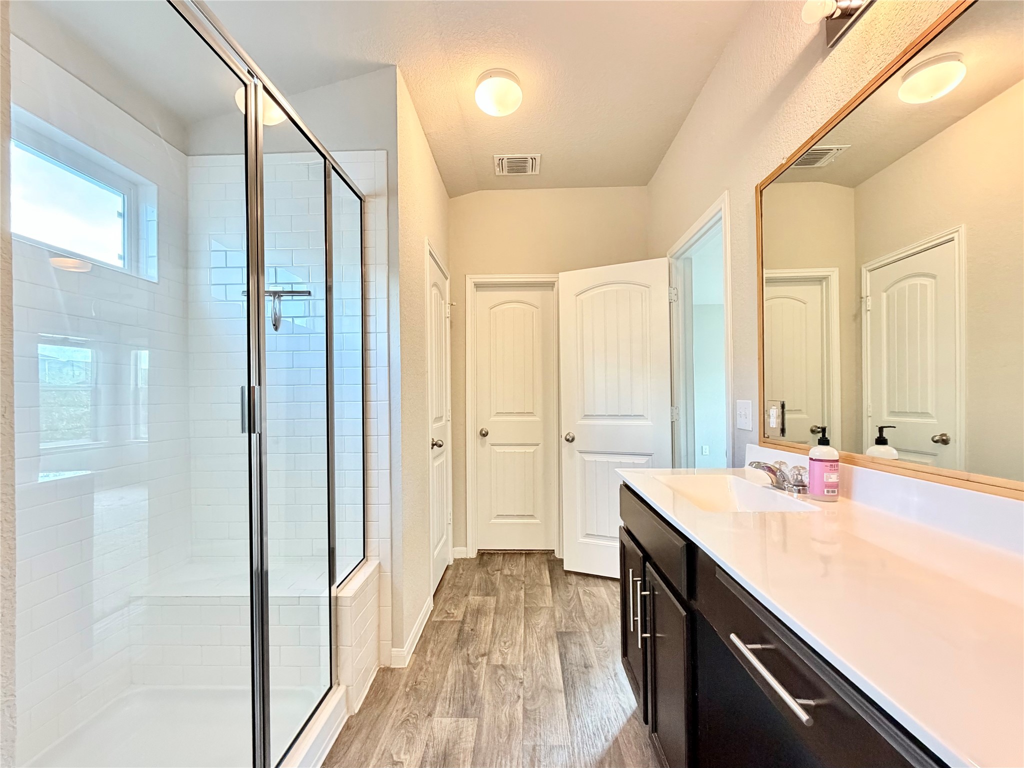 10502 Fulton Avenue Austin, TX 78754 - Photo 19 of 36 A well-appointed bathroom features a spacious glass-enclosed shower and a sleek vanity with ample counter space.