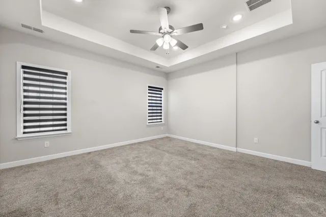 an empty room with windows and fan