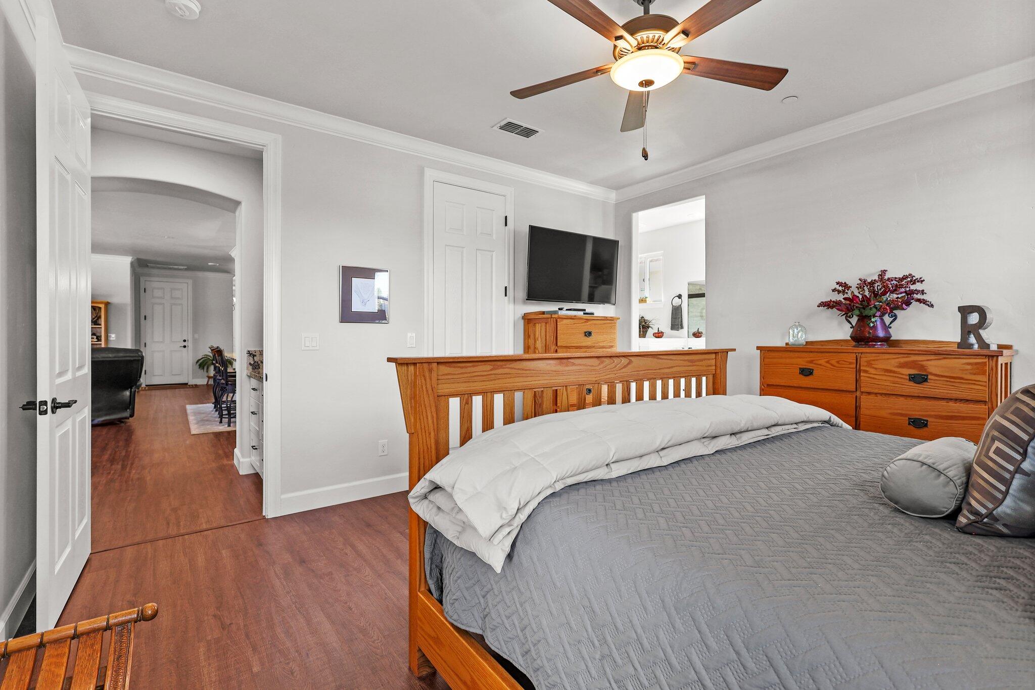 6180 Lucca Trail Redding, CA 96003 - Photo 15 of 42 a bedroom with a bed and a chandelier