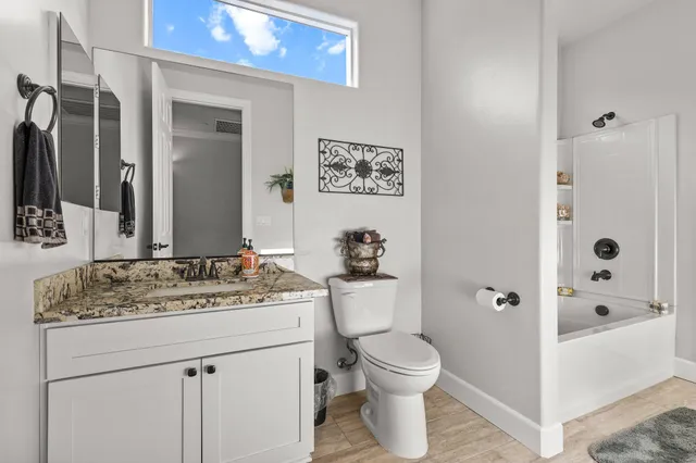 a front view of a house with a yard and car parked