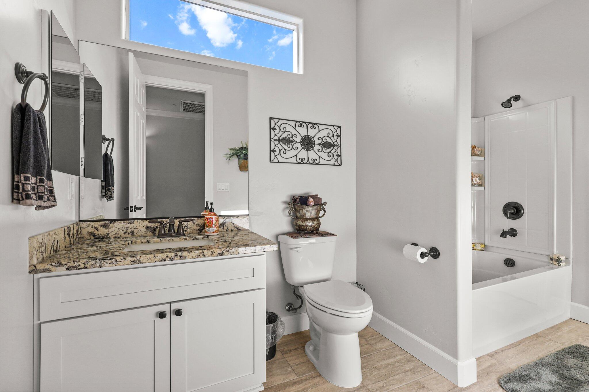6180 Lucca Trail Redding, CA 96003 - Photo 23 of 42 a bathroom with a granite countertop sink toilet and shower