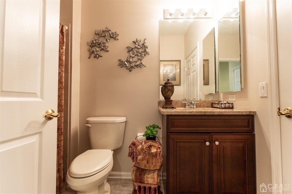 4 Merlot Court Monroe Township, NJ 08831 - Photo 12 of 17 a bathroom with a granite countertop toilet a sink and a mirror