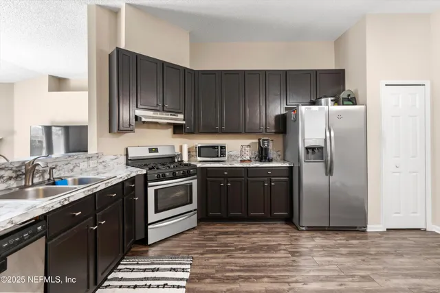 a kitchen with a stove sink and refrigerator