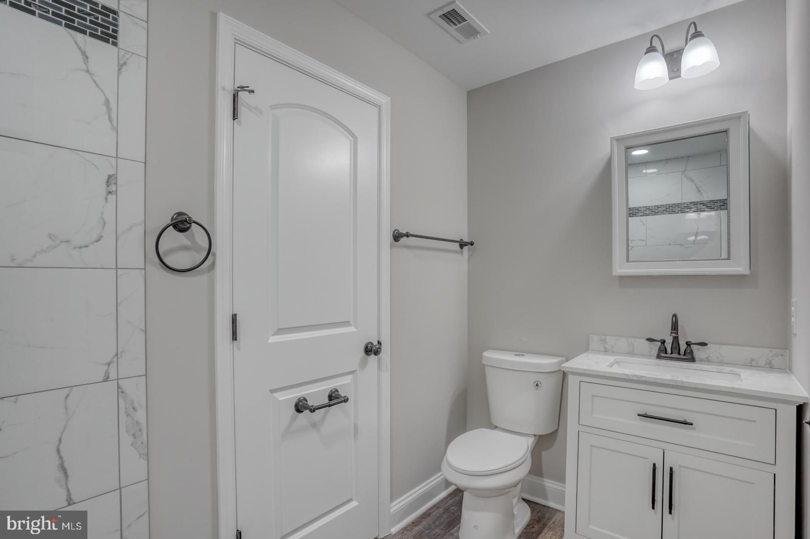 67 Morgans Choice Road Camden Wyoming, DE 19934 - Photo 31 of 56 a bathroom with a granite countertop toilet a sink a mirror and vanity