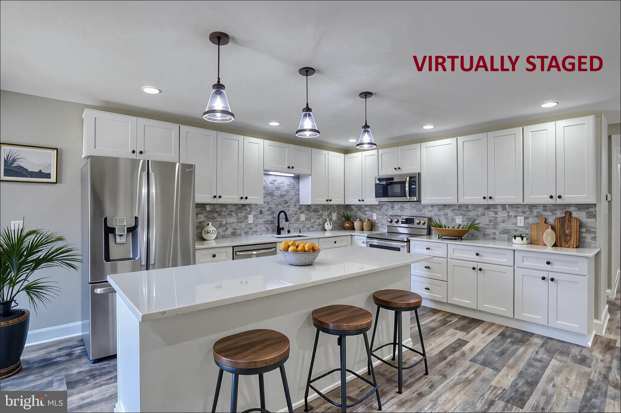 67 Morgans Choice Road Camden Wyoming, DE 19934 - Photo 47 of 56 a kitchen with stainless steel appliances granite countertop a refrigerator a sink dishwasher a stove a dining table and chairs with wooden floor