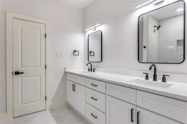 a bathroom with double vanity sinks and a mirror