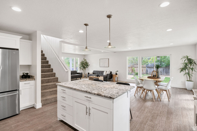 1552 Sumac Drive Logan, UT 84321 - Photo 9 of 72 Kitchen island with a light-toned countertop, white cabinetry, and pendant lighting