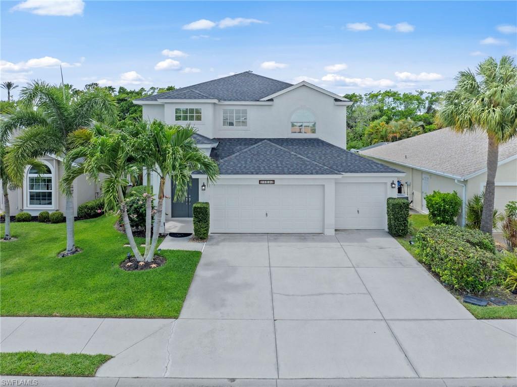 a front view of a house with a yard and trees