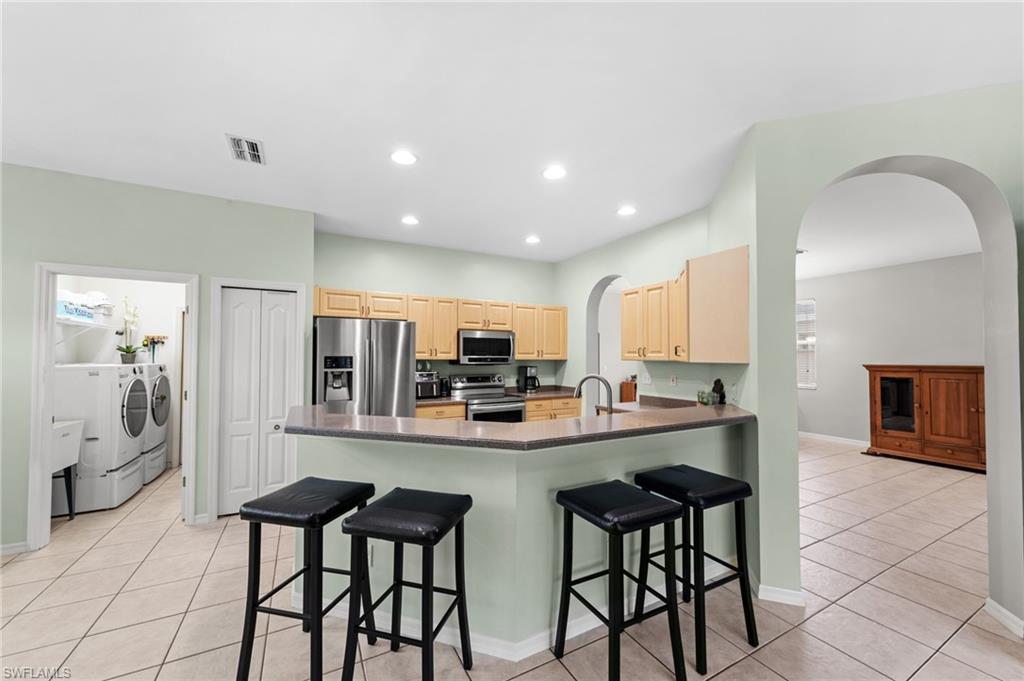 21632 Windham Run Estero, FL 33928 - Photo 11 of 50 a kitchen with stainless steel appliances a sink and cabinets