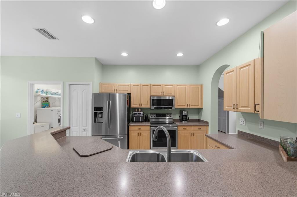 21632 Windham Run Estero, FL 33928 - Photo 12 of 50 a kitchen with stainless steel appliances granite countertop a refrigerator a stove and a sink