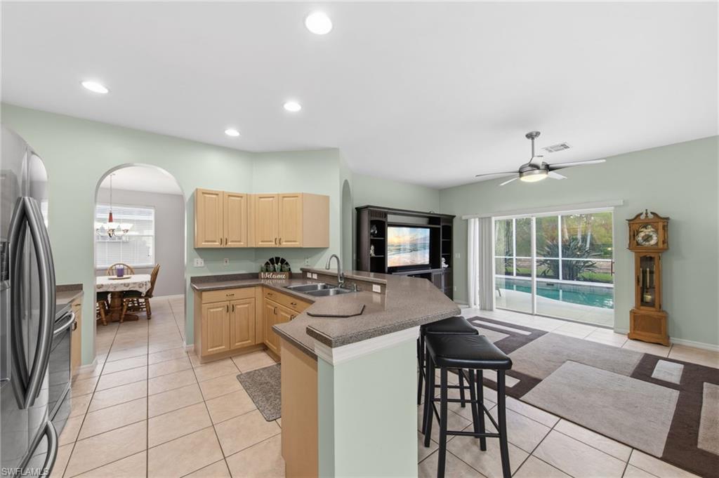21632 Windham Run Estero, FL 33928 - Photo 13 of 50 a kitchen with sink refrigerator dining table and chairs