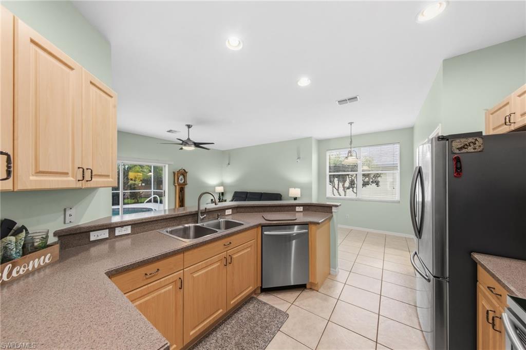 21632 Windham Run Estero, FL 33928 - Photo 15 of 50 a kitchen with stainless steel appliances granite countertop a sink stove and refrigerator