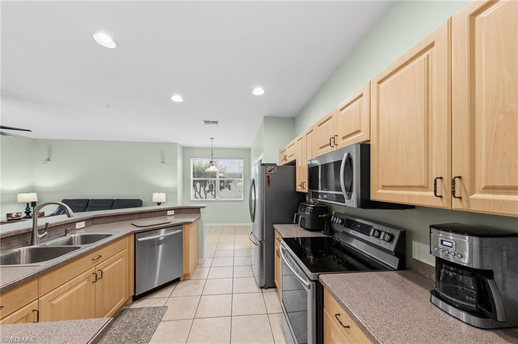 21632 Windham Run Estero, FL 33928 - Photo 16 of 50 a kitchen with stainless steel appliances granite countertop a stove a sink and a microwave