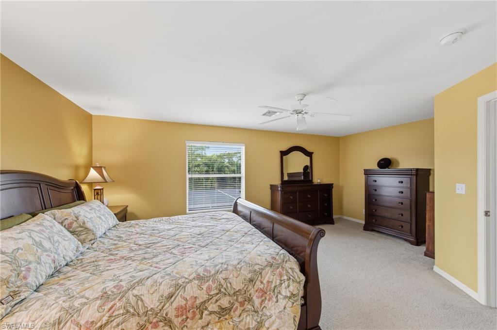 21632 Windham Run Estero, FL 33928 - Photo 24 of 50 a bedroom with a bed dresser and a large window