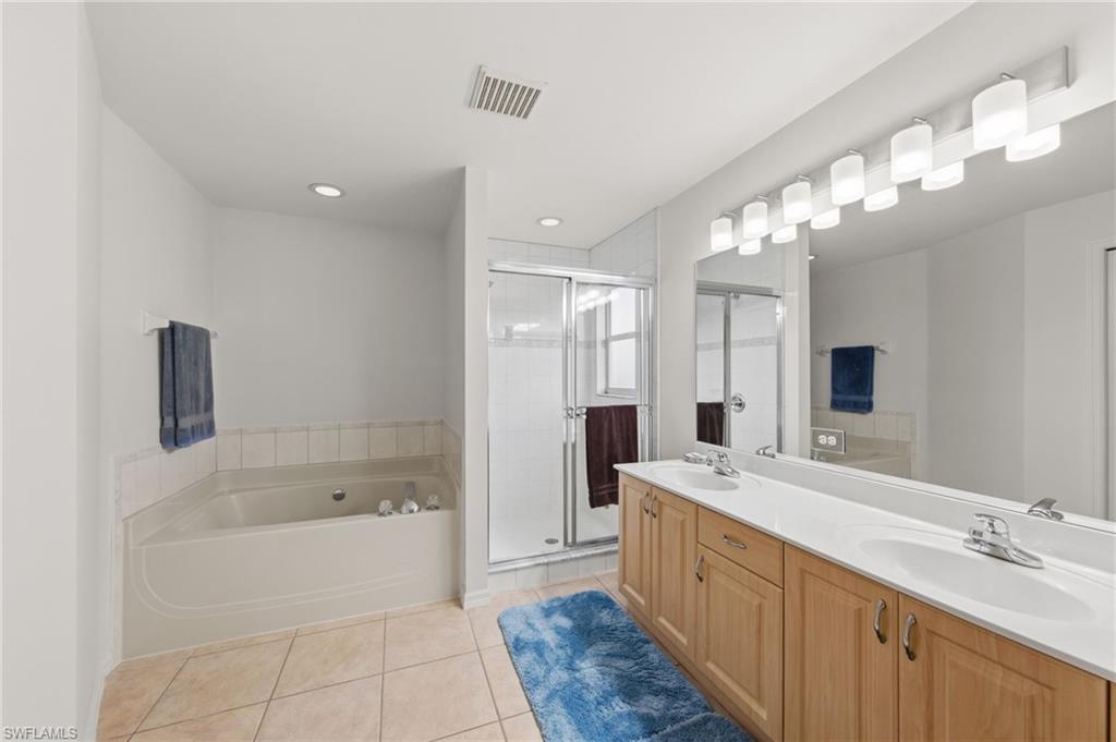 21632 Windham Run Estero, FL 33928 - Photo 25 of 50 a large spacious bathroom with a double vanity sink a large mirror and a bathtub