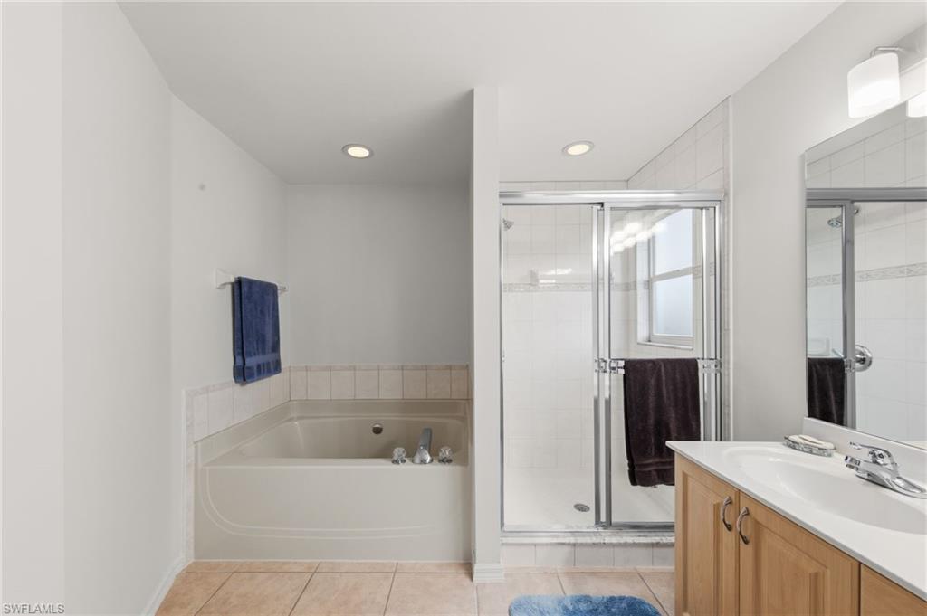 21632 Windham Run Estero, FL 33928 - Photo 26 of 50 a bathroom with a bathtub a mirror a double vanity sink and vanity
