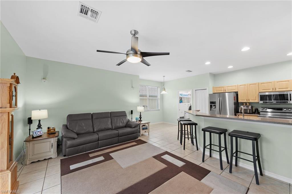 21632 Windham Run Estero, FL 33928 - Photo 10 of 50 a living room with furniture a ceiling fan and a kitchen view