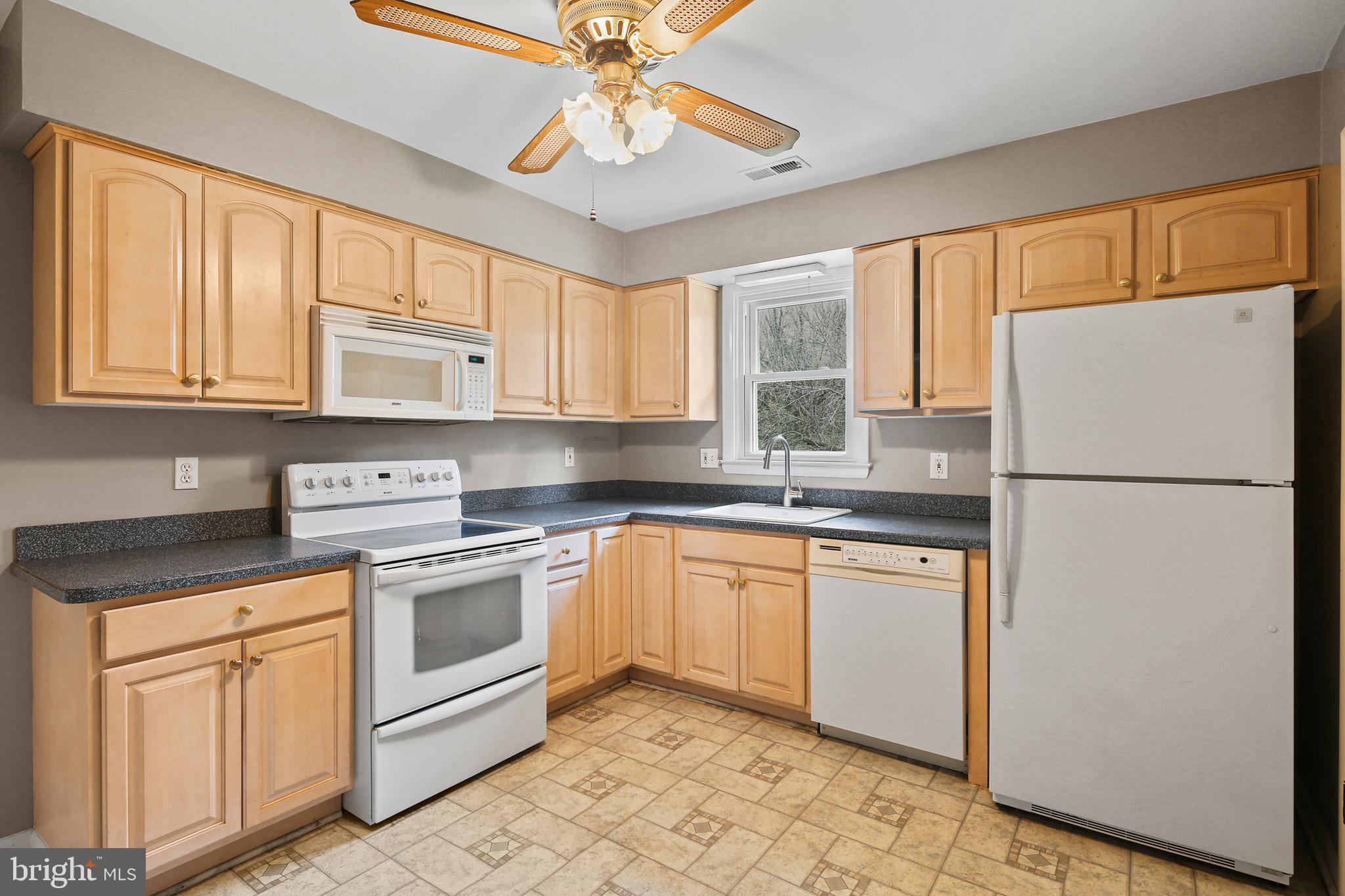 9826 Fox Hill Road Perry Hall, MD 21128 - Photo 13 of 45 a kitchen with stainless steel appliances granite countertop a refrigerator a stove a sink and a microwave