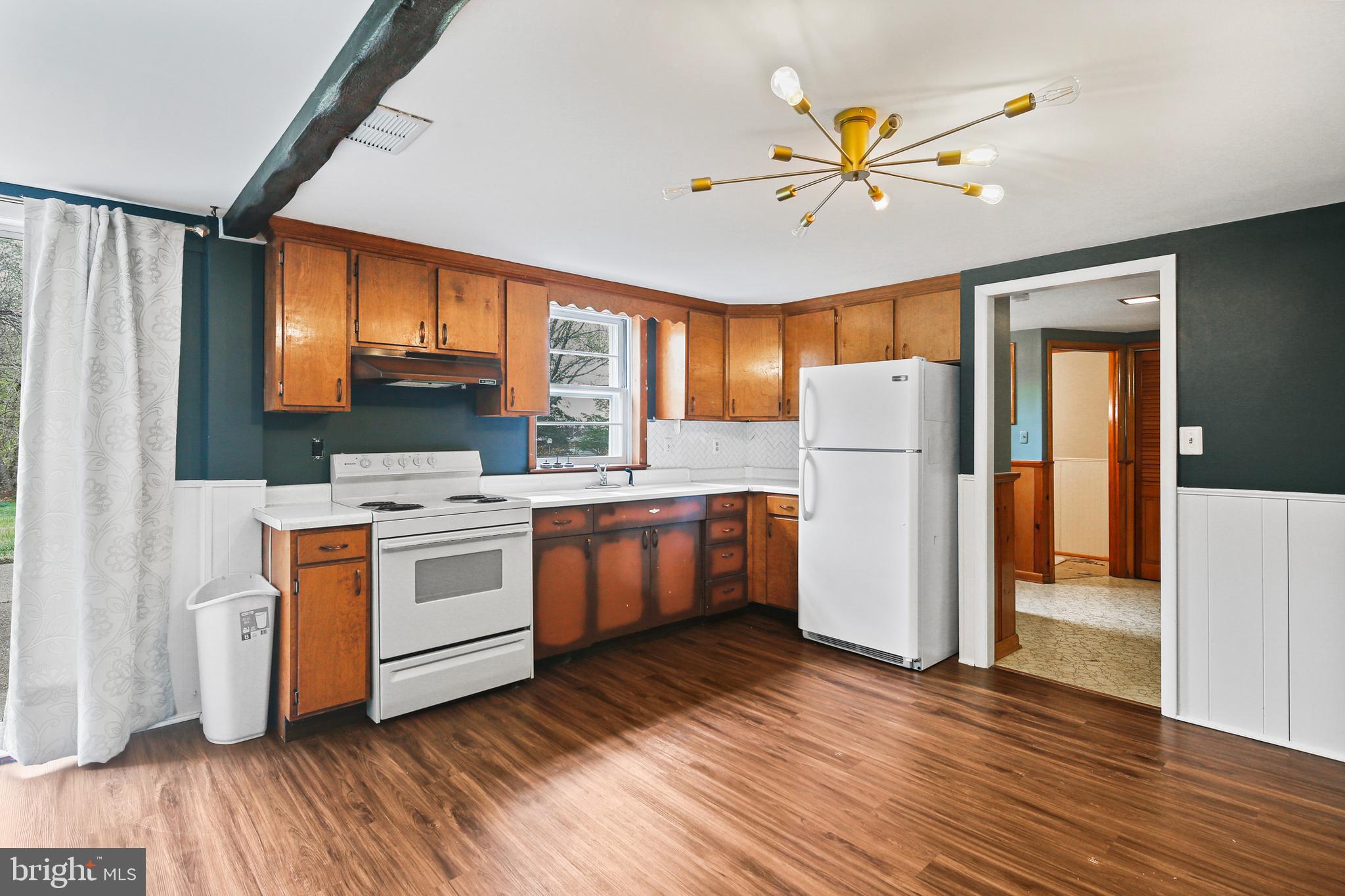 9826 Fox Hill Road Perry Hall, MD 21128 - Photo 28 of 45 a kitchen with a refrigerator a stove top oven a sink and dishwasher with wooden floor