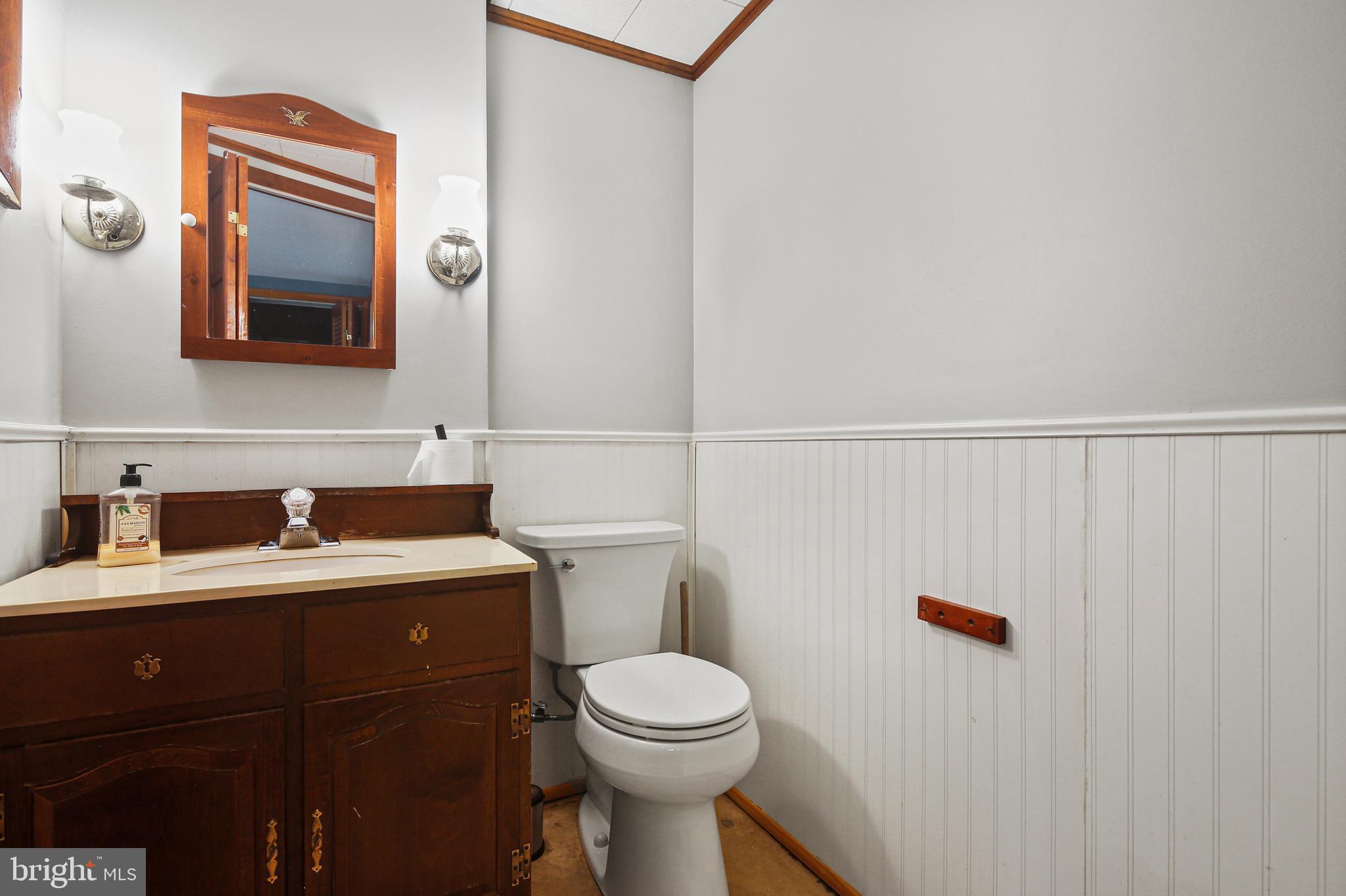9826 Fox Hill Road Perry Hall, MD 21128 - Photo 33 of 45 a bathroom with a toilet a sink and mirror