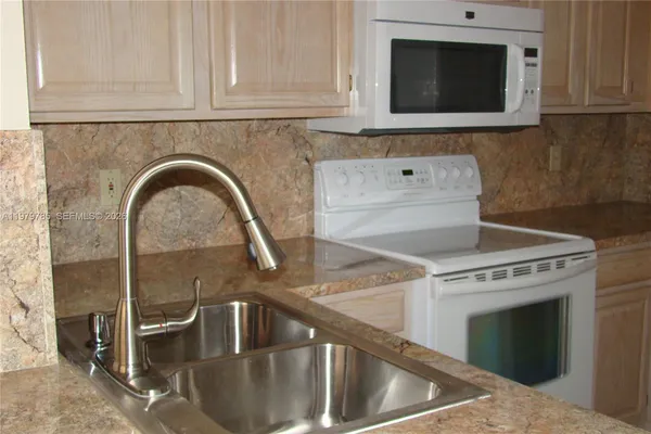 a kitchen with granite countertop a stove and a microwave