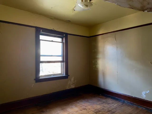 a bed sitting in a bedroom next to a window