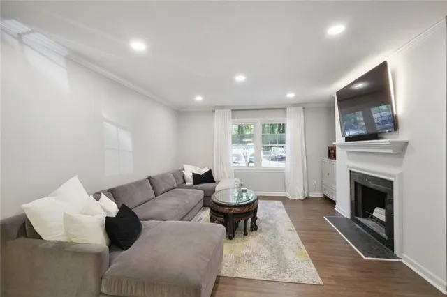 a living room with furniture a flat screen tv and a fireplace