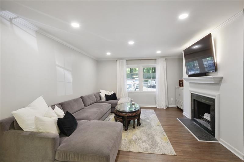 162 Elysian Way Northwest Atlanta, GA 30327 - Photo 8 of 32 a living room with furniture a flat screen tv and a fireplace