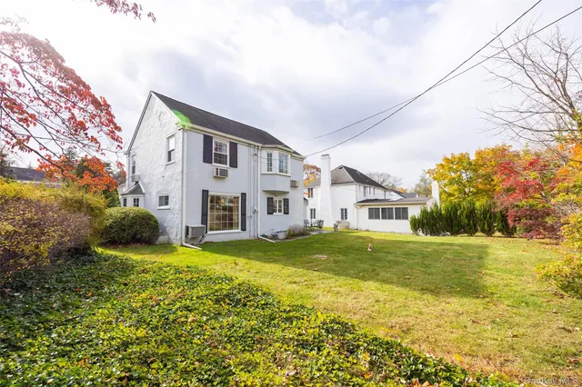 a view of a house with a big yard and large trees