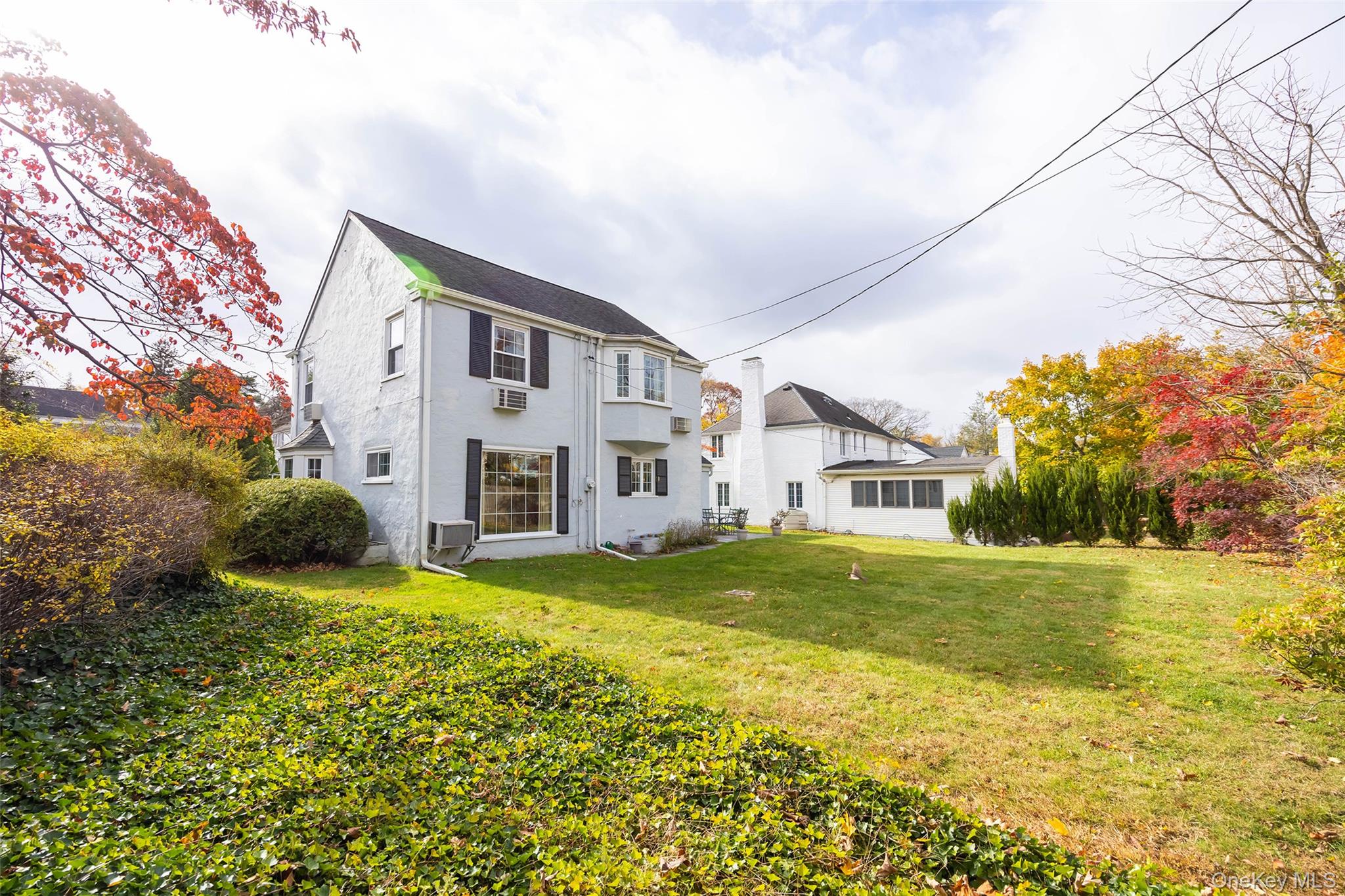 65 Old Mill Road Manhasset, NY 11030 - Photo 16 of 17 a view of a house with a big yard and large trees