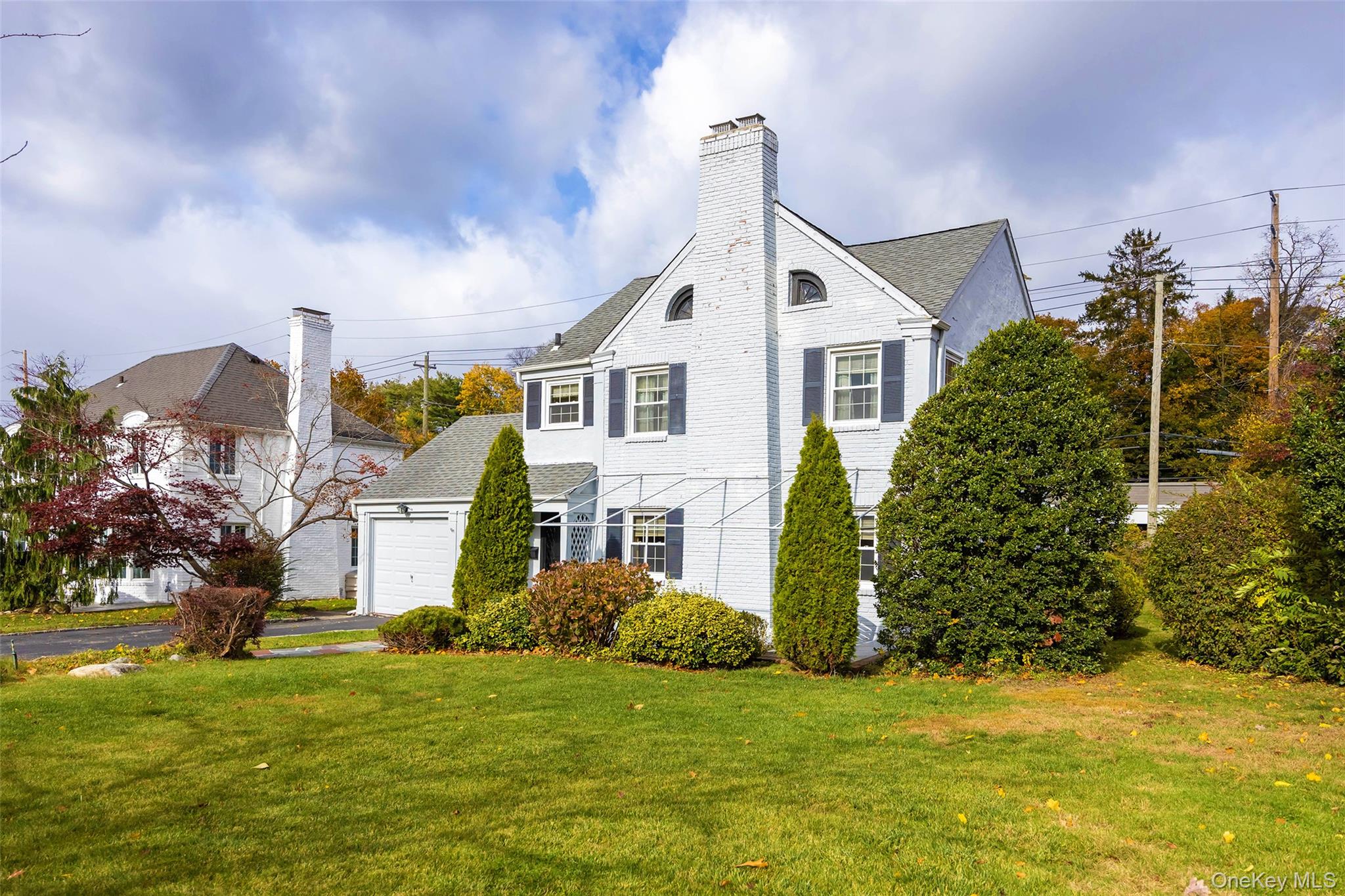 65 Old Mill Road Manhasset, NY 11030 - Photo 2 of 17 a front view of a house with a garden