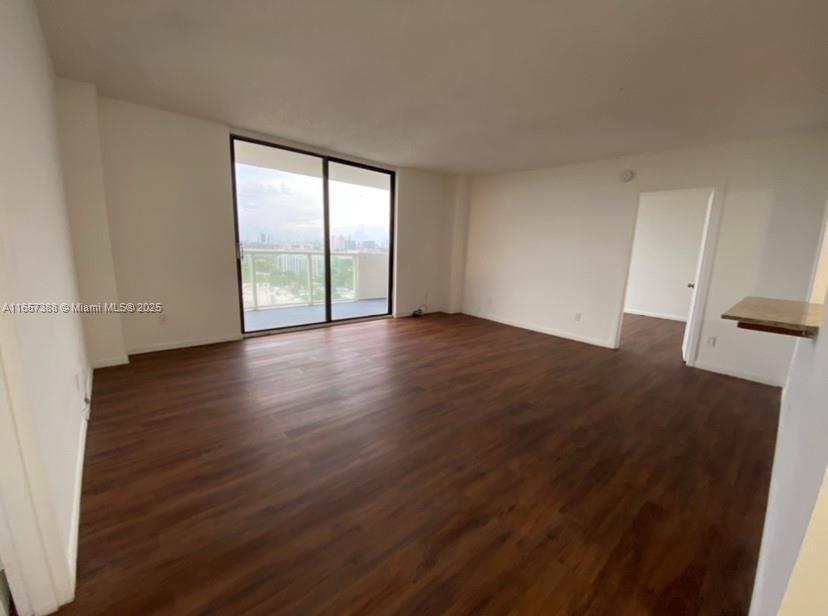 13499 Biscayne Boulevard, Unit 1507 North Miami, FL 33181 - Photo 14 of 32 an empty room with wooden floor and windows