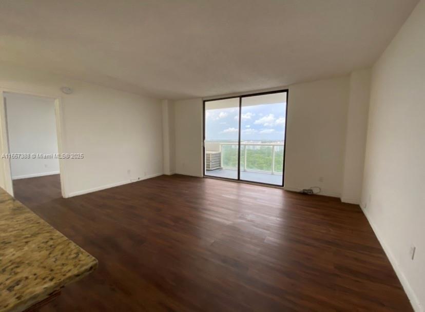 13499 Biscayne Boulevard, Unit 1507 North Miami, FL 33181 - Photo 15 of 32 a view of an empty room with wooden floor and a window