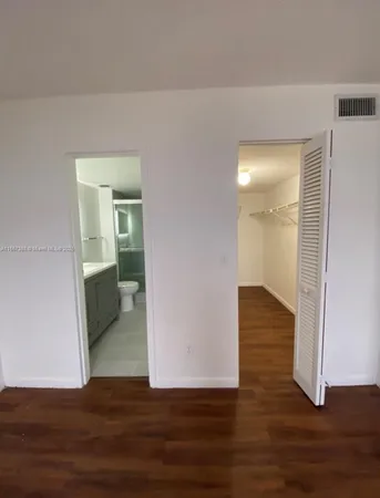 a view of a room with wooden floor and a bathroom