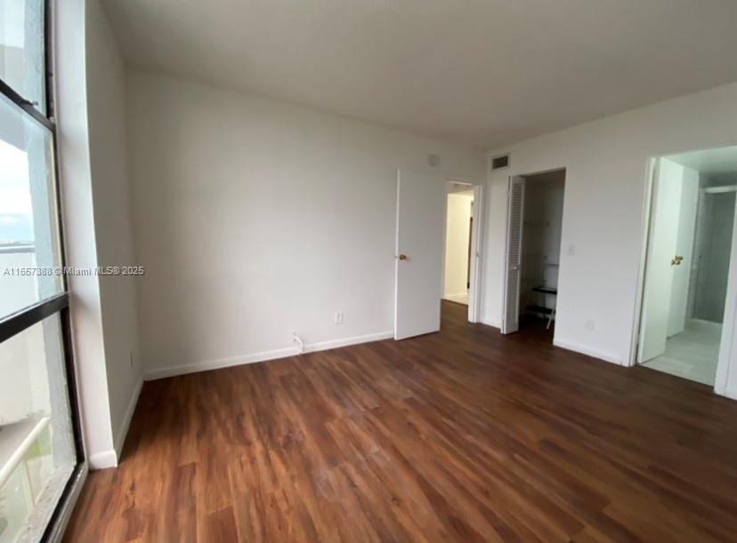 13499 Biscayne Boulevard, Unit 1507 North Miami, FL 33181 - Photo 26 of 32 a view of an empty room with wooden floor and a window