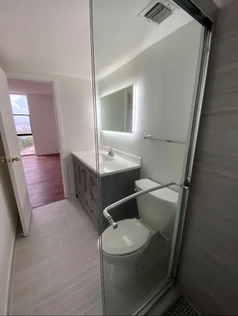 a bathroom with a toilet a sink and mirror