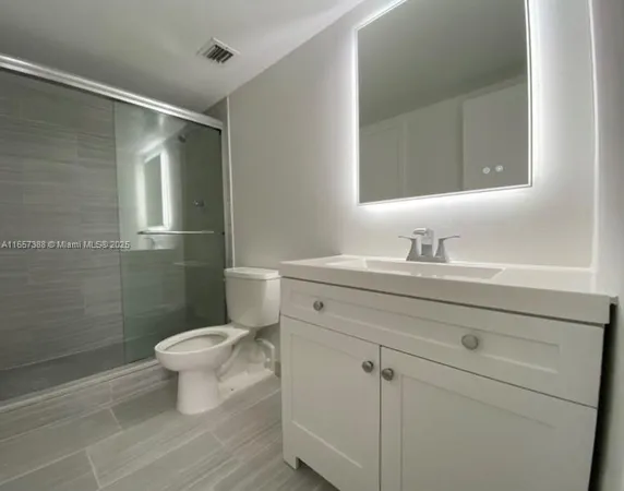 a bathroom with a sink toilet a mirror and shower