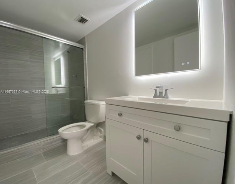 13499 Biscayne Boulevard, Unit 1507 North Miami, FL 33181 - Photo 9 of 32 a bathroom with a sink toilet a mirror and shower