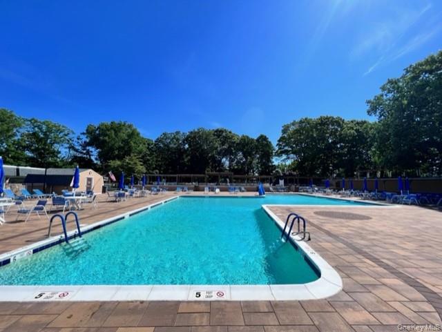 171 B Ventry Court, Unit 171B Ridge, NY 11961 - Photo 19 of 19 a view of a swimming pool with a yard and sitting area