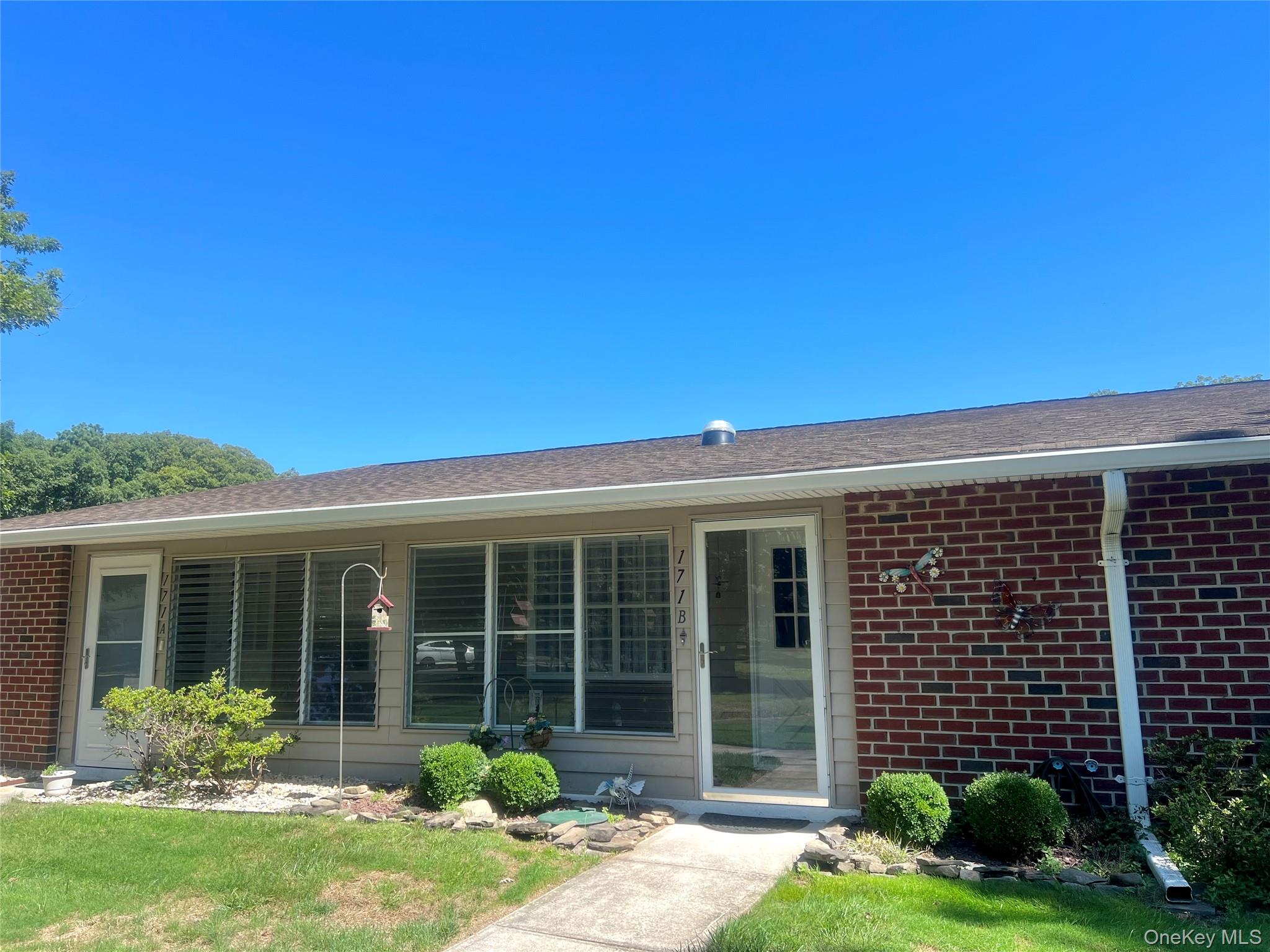 171 B Ventry Court, Unit 171B Ridge, NY 11961 - Photo 2 of 19 front view of a house with a yard