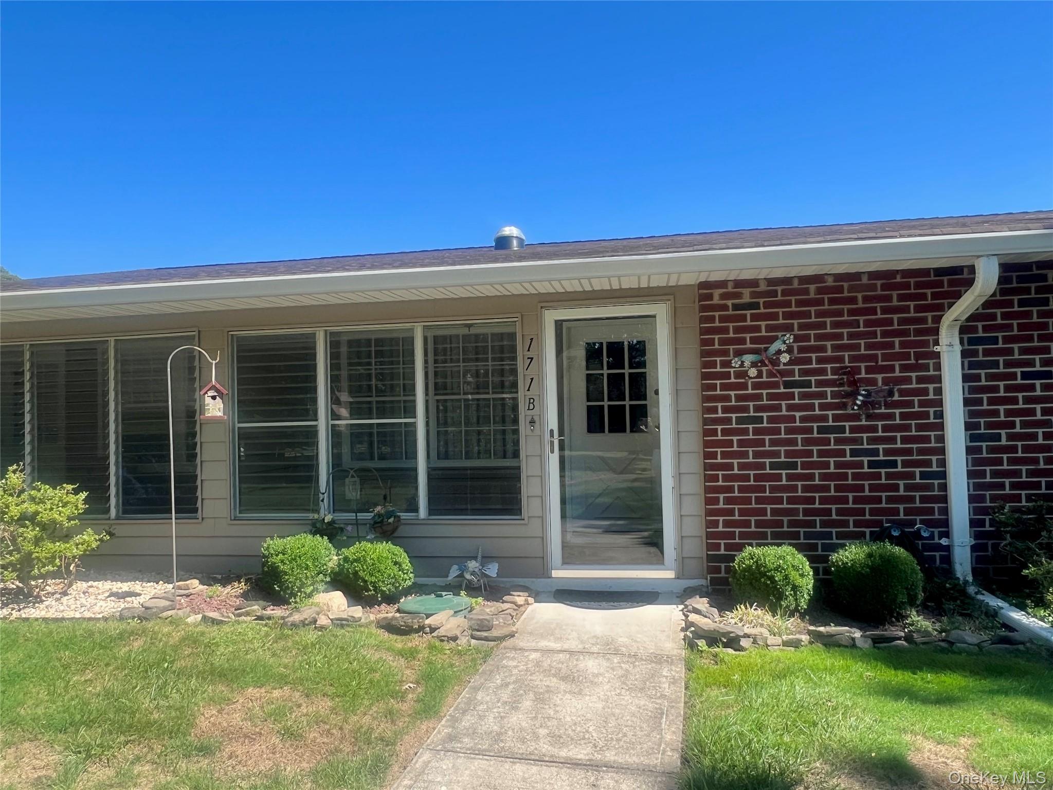 171 B Ventry Court, Unit 171B Ridge, NY 11961 - Photo 3 of 19 a view of a house with a yard and plants