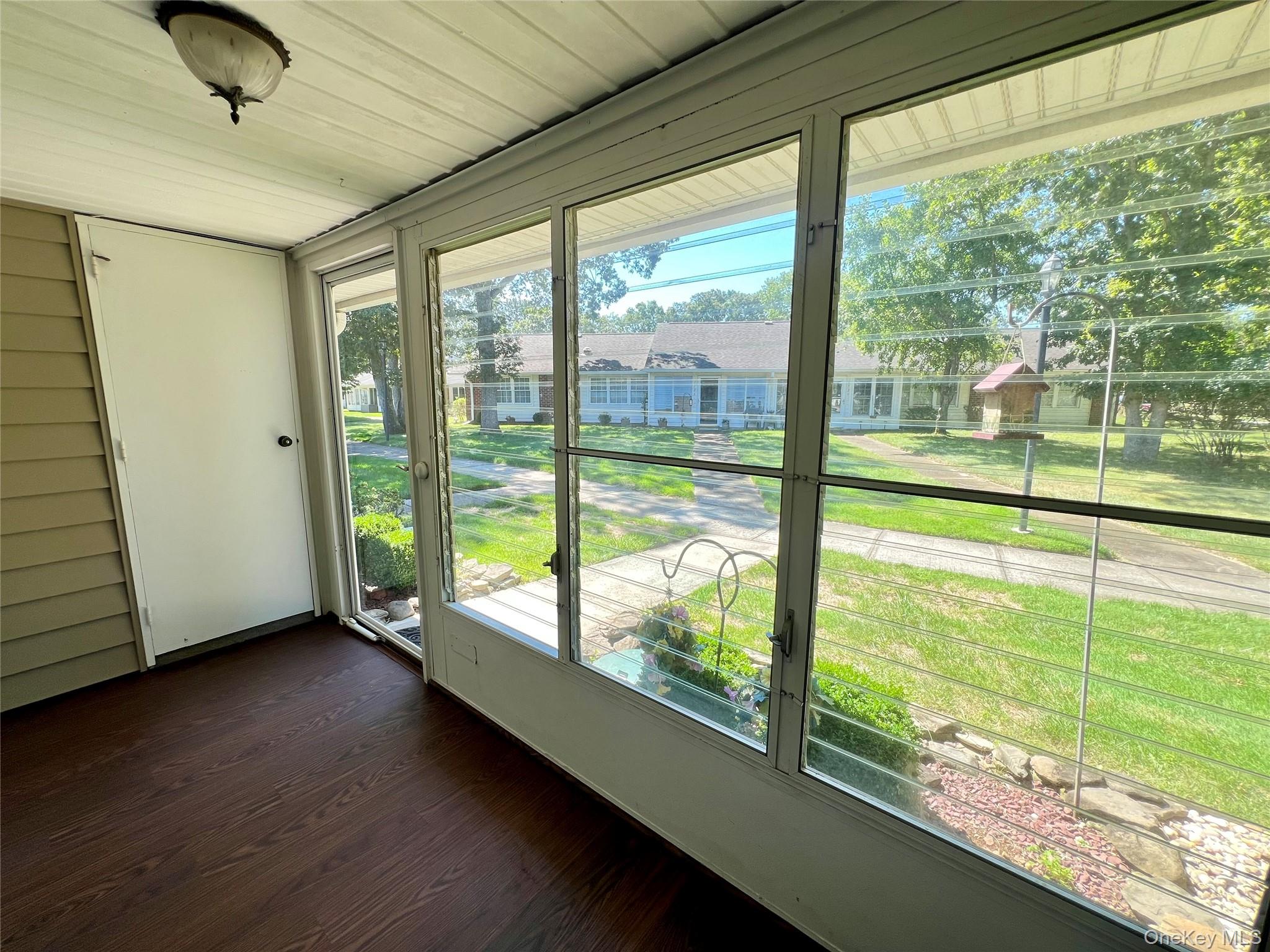 171 B Ventry Court, Unit 171B Ridge, NY 11961 - Photo 4 of 19 a view of an empty room with wooden floor and a window