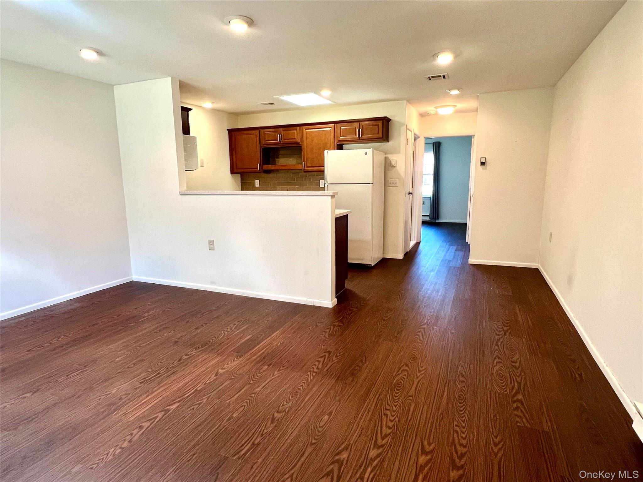 171 B Ventry Court, Unit 171B Ridge, NY 11961 - Photo 5 of 19 a view of a kitchen with a fridge and wooden floor