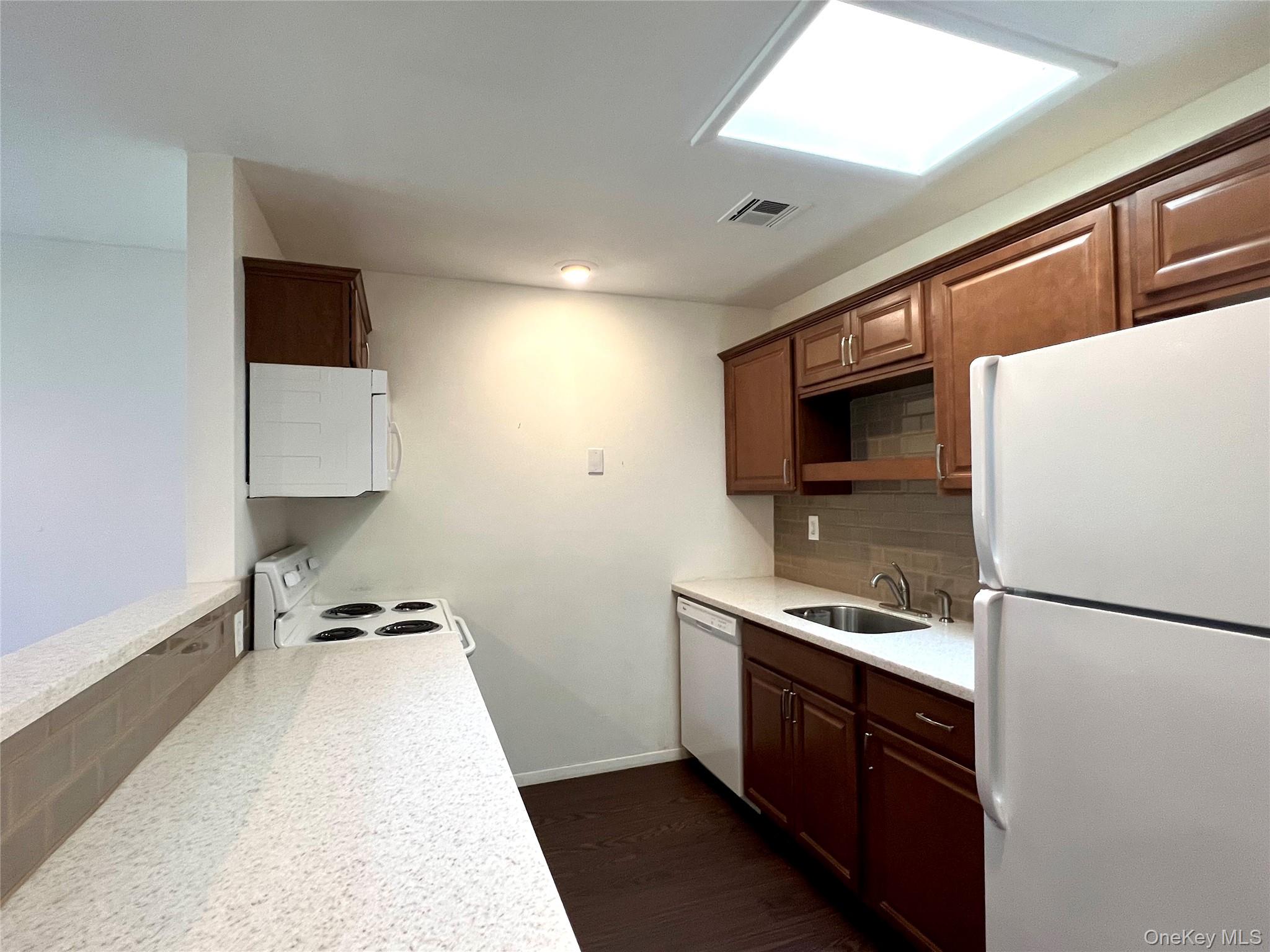 171 B Ventry Court, Unit 171B Ridge, NY 11961 - Photo 9 of 19 a kitchen with stainless steel appliances a refrigerator and a stove top oven