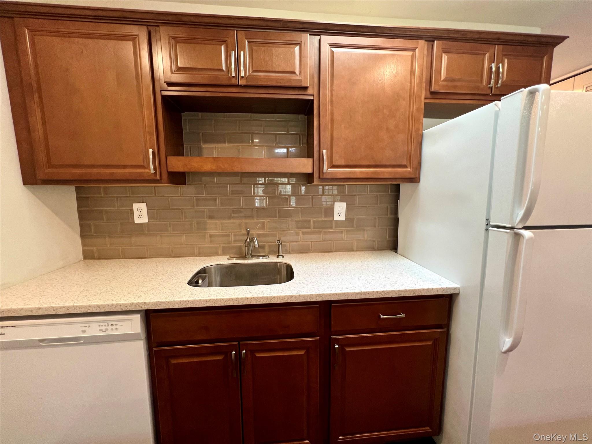 171 B Ventry Court, Unit 171B Ridge, NY 11961 - Photo 10 of 19 a kitchen with a sink and a refrigerator