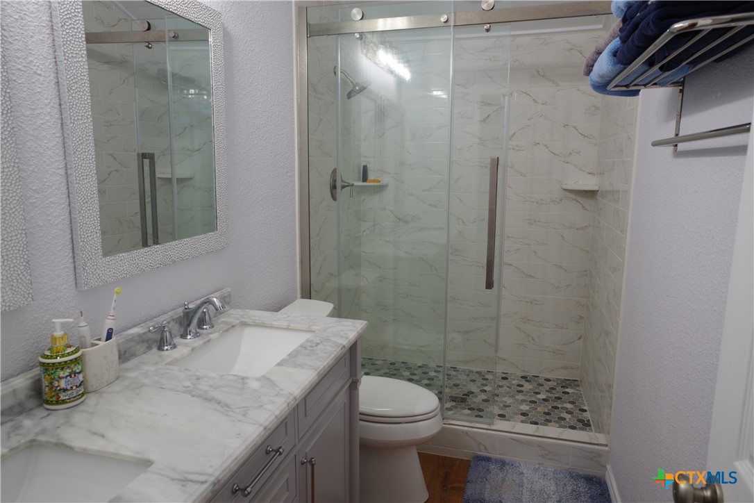 15049 Ranch Road 101 Kempner, TX 76539 - Photo 11 of 25 a bathroom with a granite countertop sink toilet and shower