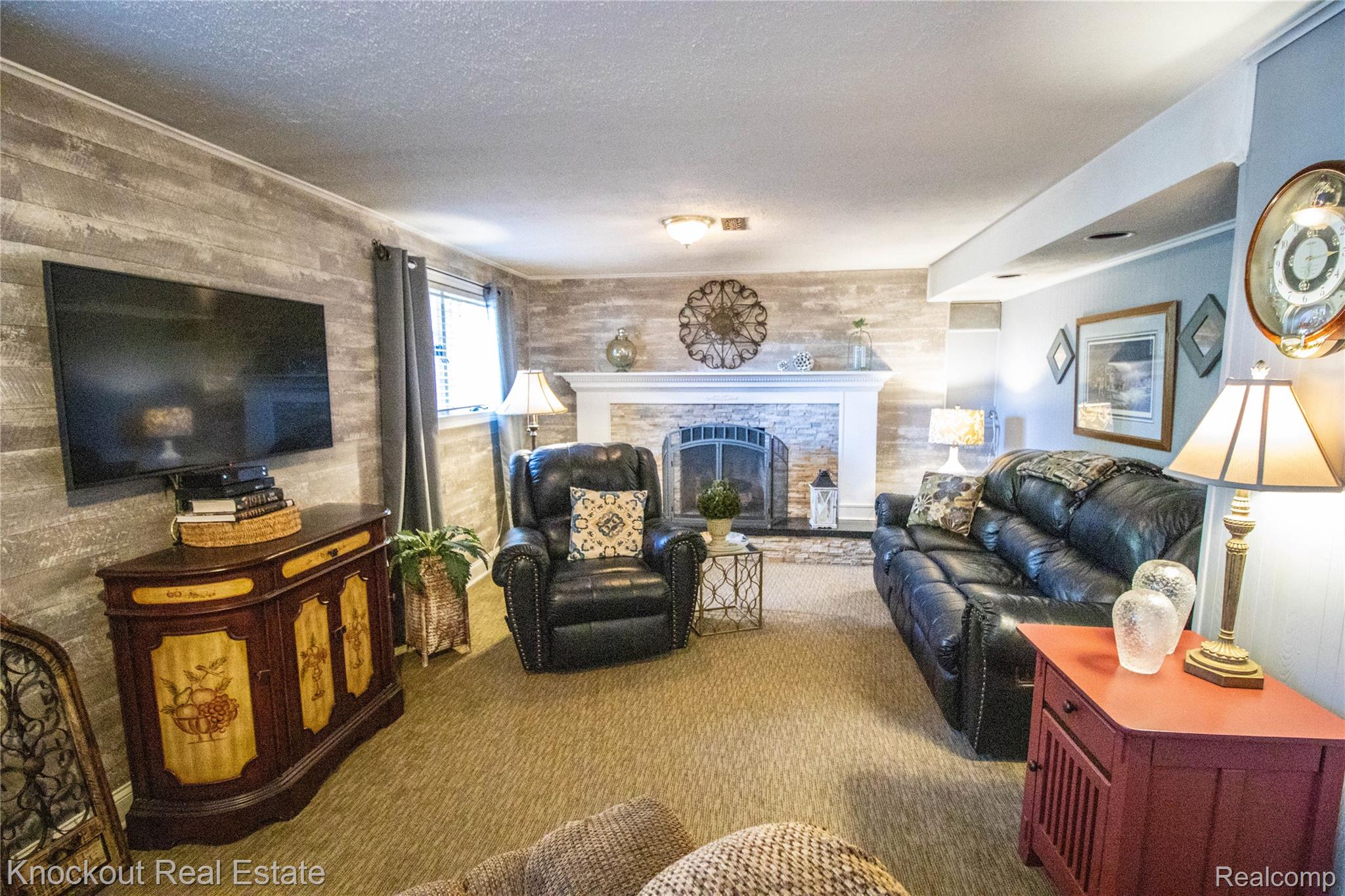14720 Lincoln Road Chesaning, MI 48616 - Photo 35 of 60 Stone-face fireplace with a white mantel, wood-look plank accent wall, and recessed lighting
